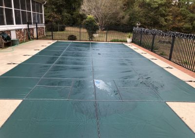 A green safety cover on an inground pool in Chesterfield, Virginia.